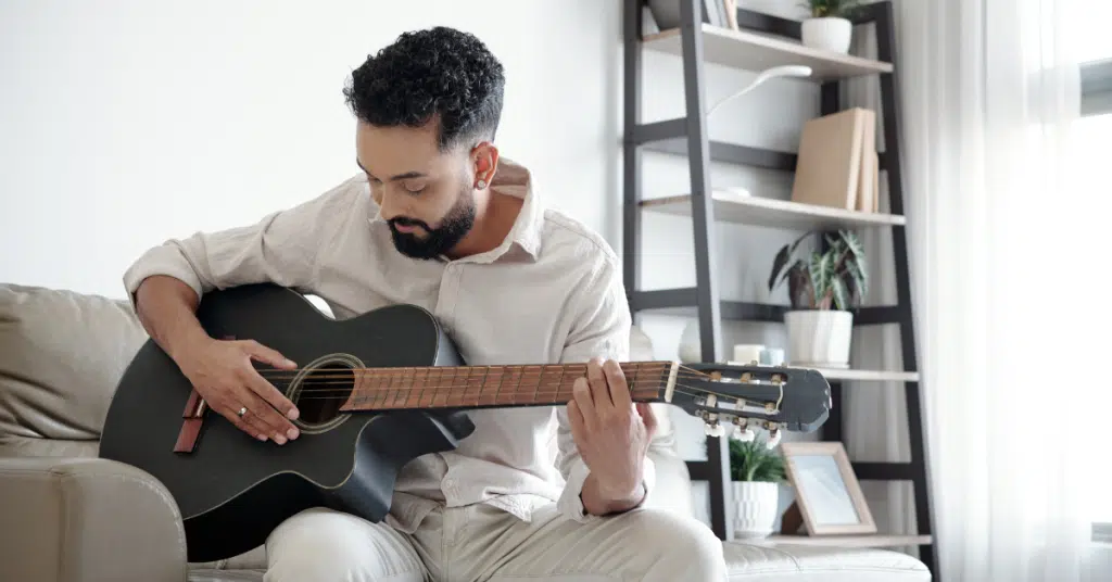 a man is relaxed and in flow state while playing the guitar