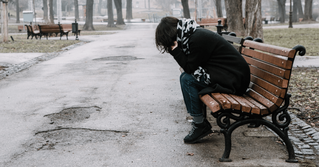 lonely person sitting on a bench who has a low mood