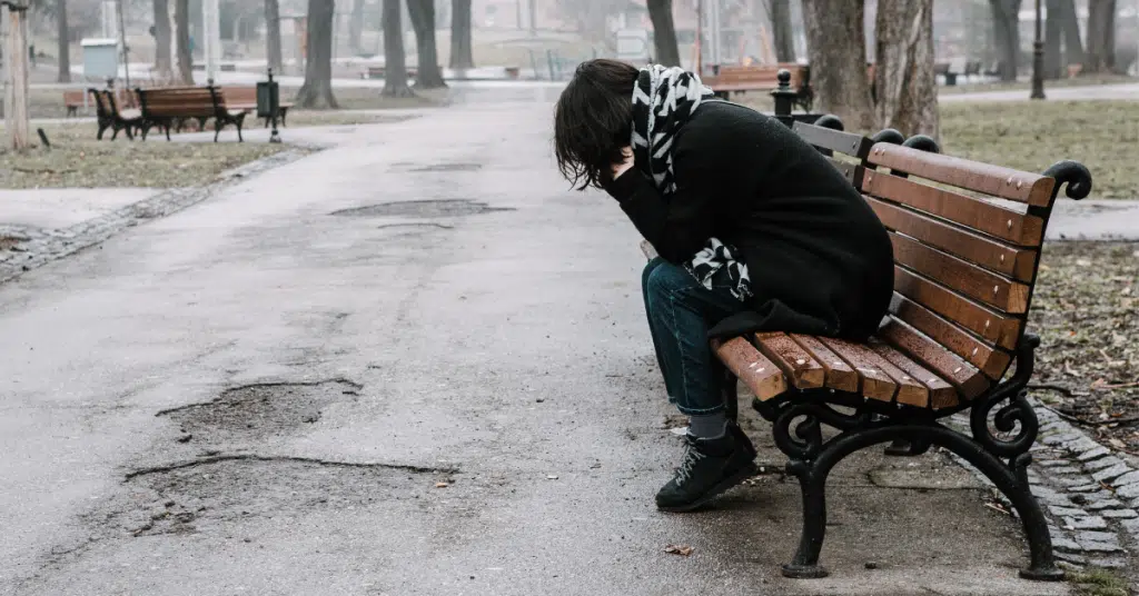 lonely person sitting on a bench who has a low mood