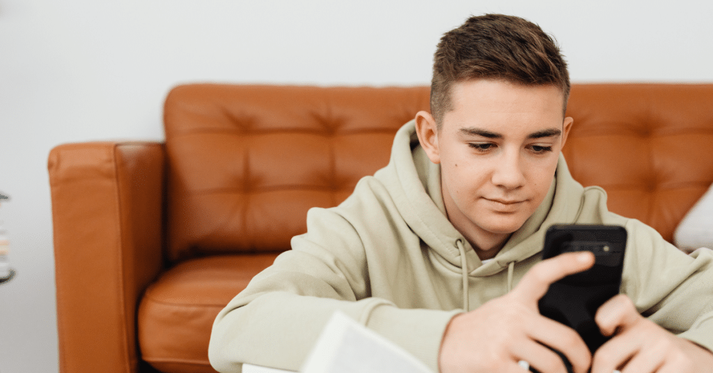 teen boy using his phone to access an AI chatbot for health questions