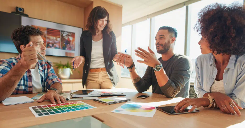 a man talks to a work group, overcoming the imposter syndrome he feels while in an important meeting
