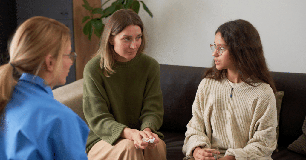 a teen girl with her mom as they do family therapy while at inpatient mental health treatment