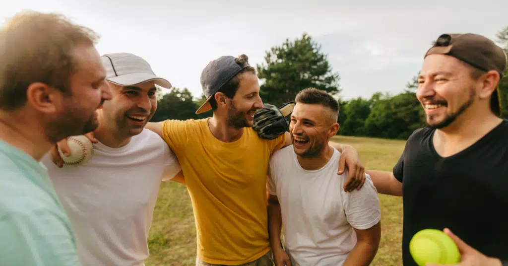 a group of men supporting each other with body image by playing sports
