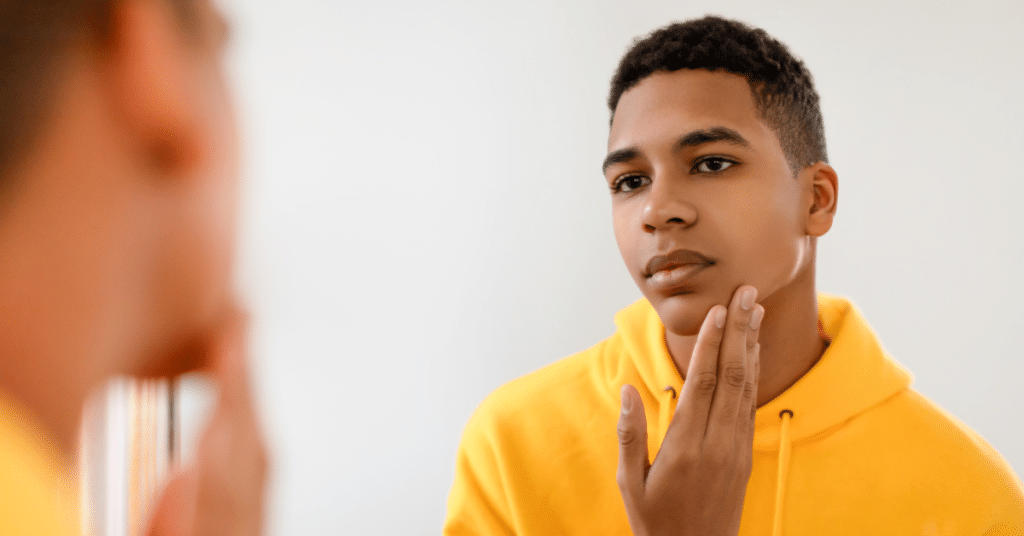 mogging affected a teen's body image while looking in a mirror