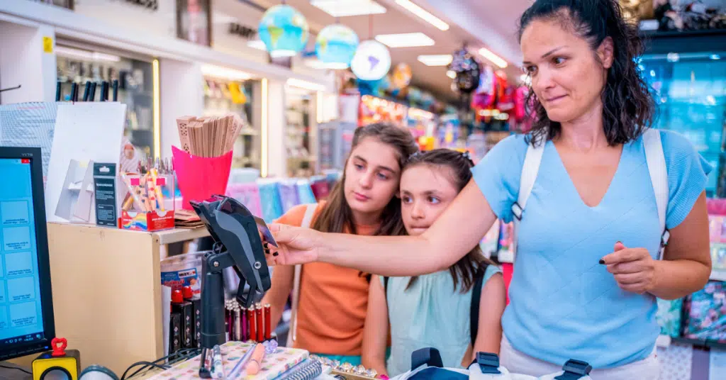 mom paying for supplies for teens navigating brand envy