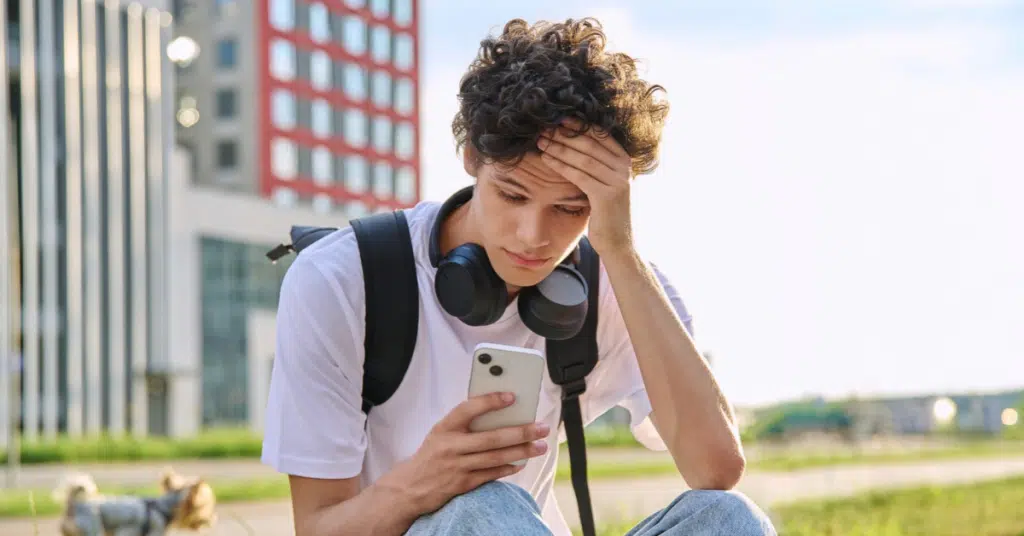 young man becomes overwhelmed with sunday anxiety while on his phone